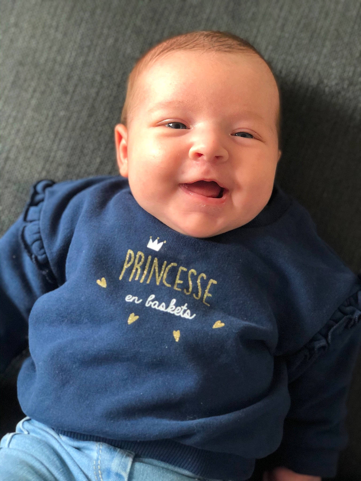 Mia participe au concours pour gagner de l'argent avec cette photo : baby, baby_toddler_clothing, cheek, child, chin, cool, face, facial_expression, forehead, happy, head, nose, person, sitting, skin, sleeve, smile, t_shirt, toddler