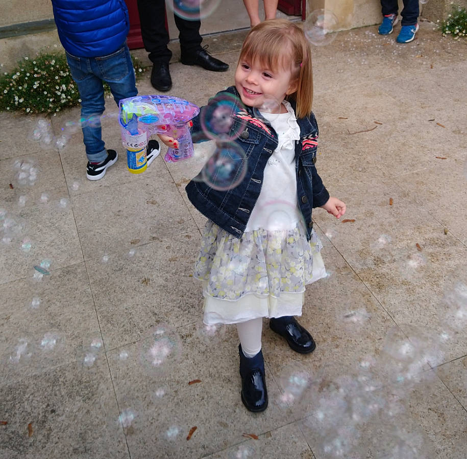 Manon participe au concours pour gagner de l'argent avec cette photo : asphalt, boot, child, city, event, fun, grass, happy, head, joy, leg, leisure, person, recreation, road_surface, shoe, sidewalk, sitting, smile, sneakers