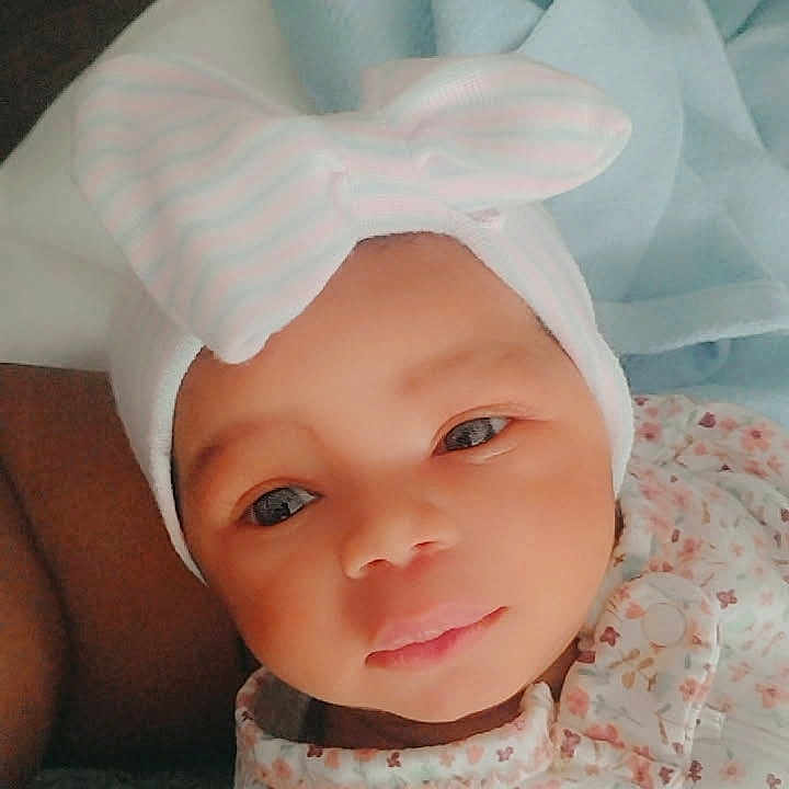 Dalyla joined the competition — help win amazing prizes! baby, infant, child, portrait, face, eyes, looking_at_camera, floral_outfit, headband, bow, blanket, bedding, lying_down, indoor, cozy, cute, calm, close_up, photography, soft_lighting