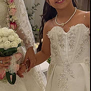 Leen is registered to the contest to win money with this photo: bouquet, bride, celebration, ceremony, child, dress, floral_arrangement, flowers, formalwear, girl, gown, indoors, jewelry, long_hair, necklace, portrait, smiling, tiara, wedding, white_dress