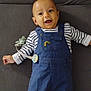 Noa a rejoint le concours — aidez-le/la à gagner de superbes lots ! baby, smiling, blue_overalls, striped_shirt, pacifier, clip, blanket, gray_surface, happy, child, infant, cute, lying_down, indoors, casual_clothing, person, portrait, young_child, cheerful, baby_boy