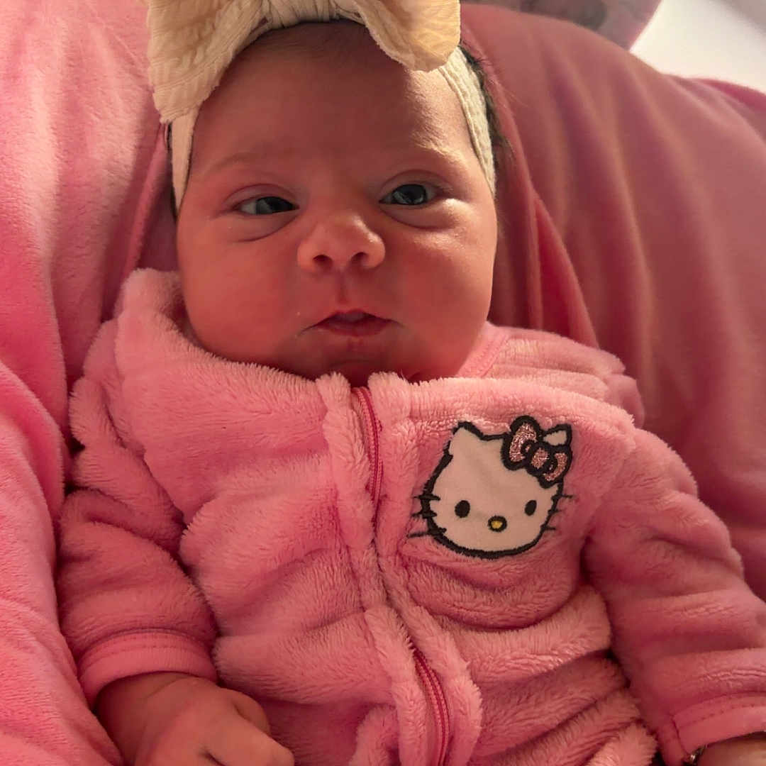 Caisleigh Belle joined the competition — help win amazing prizes! baby, blanket, bow, child, clothing, comfortable, cozy, cute, face, hand, headband, hello_kitty, indoors, infant, newborn, onesie, person, pink, portrait, soft_texture