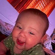 Cielo joined the competition — help win amazing prizes! baby, child, smiling, face, indoors, curtains, bed, blanket, pillow, clothing, green_shirt, happy, closeup, cheeks, person, infant, portrait, soft_light, crawling, home