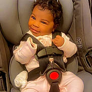 Legacy is registered to the contest to win money with this photo: baby, car_seat, child, smiling, pink_pajamas, infant, face, seatbelt, strapped_in, cute, indoors, winking, headrest, clothing, person, safety_harness, dove_graphic, text_overlay, happy, portrait
