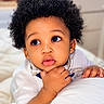 baby, child, closeup, curly_hair, cute, expression, eyes, face, hand, indoor, infant, pillow, portrait, resting, skin, soft_texture, thoughtful, toddler, white_clothing, young_child