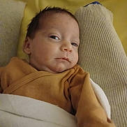 Melyssandre participe au concours pour gagner de l'argent avec cette photo : baby, infant, blanket, clothing, bed, sleepy, face, person, newborn, cozy, yellow, mustard, lying_down, portrait, indoors, skin, head, expression, child, soft_fabric