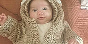Ava participe au concours pour gagner de l'argent avec cette photo : baby, infant, knitted_clothing, hoodie, bear_ears, blanket, bed, pink_pants, cute, smiling, face, hand, cozy, soft_texture, indoor, child, person, warm, lying_down, comfortable