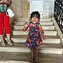 architecture, casual, child, floral_dress, girl, handbag, happy, indoor, joyful, person, portrait, railing, red_pants, sandals, smiling, sneakers, stairs, stone_wall, waving, woman