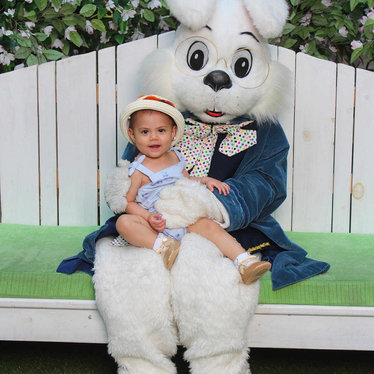 Nita is registered to the contest to win money with this photo: bench, bunny_costume, child, costume, family_event, fence, floral_background, flowers, grass, green_cushion, hat, holiday_photo, mascot, outdoor, person, plush, portrait, sitting, smile, toddler