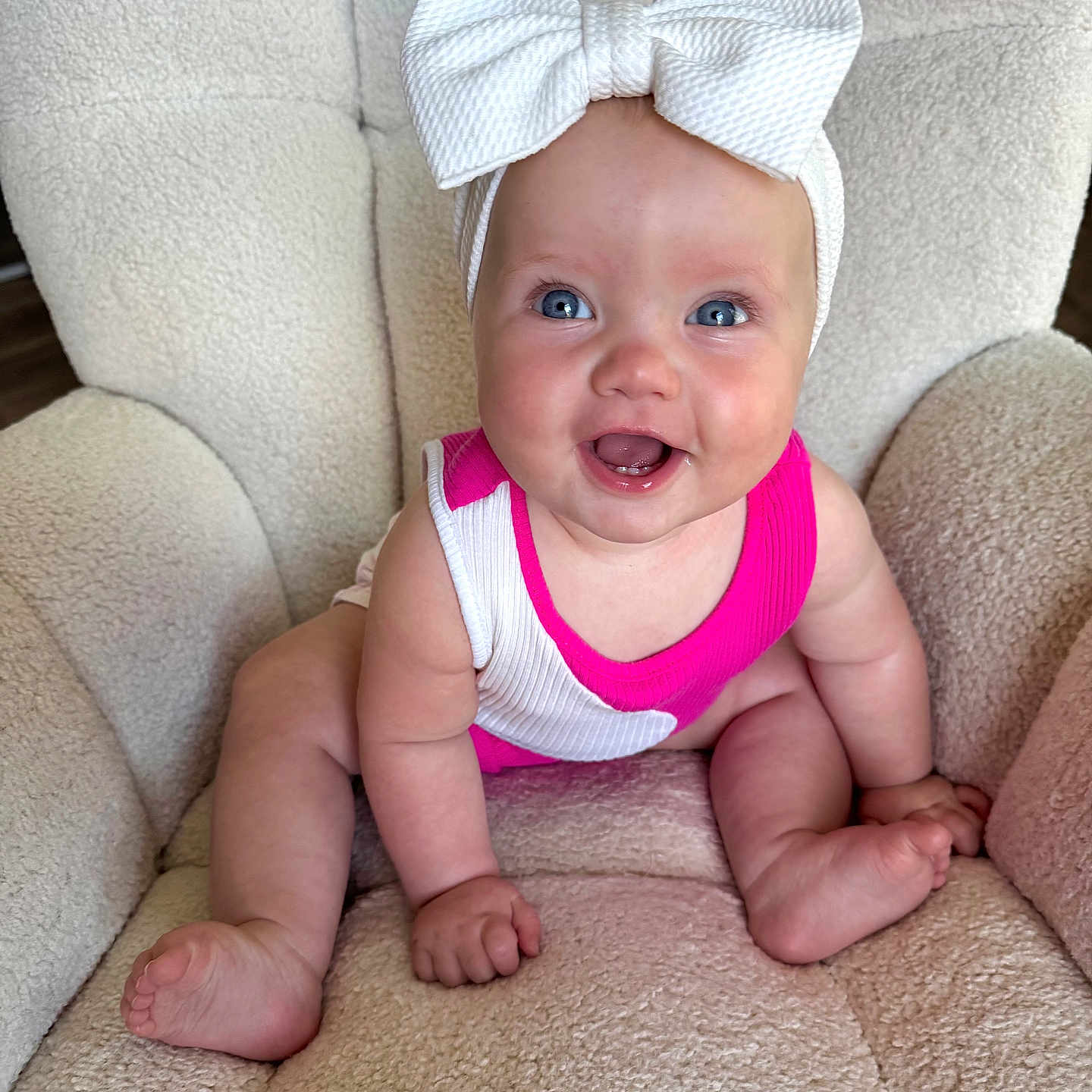 Wrenlee joined the competition — help win amazing prizes! baby, blue_eyes, bow, child, comfort, cute, foot, hand, happy, headband, human, indoors, infant, pink_clothing, plush_chair, portrait, sitting, skin, smiling, soft_texture