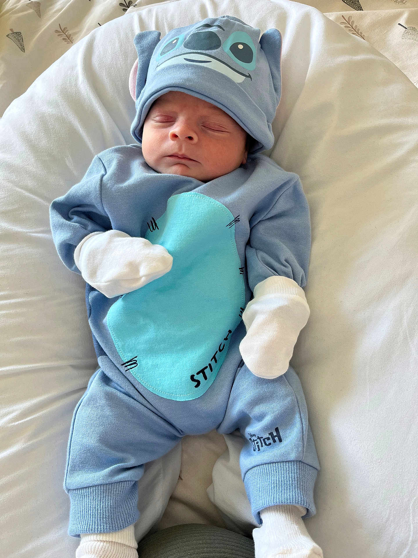 Alfie is registered to the contest to win money with this photo: newborn, baby, sleeping, blue_outfit, hat, mittens, stitch, disney, infant, cute, soft_blanket, clothing, resting, white, portrait, child, indoors, comfortable, peaceful, babywear