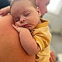 Alfie joined the competition — help win amazing prizes! baby, sleeping, child, person, adult, shoulder, hand, face, skin, closeup, portrait, yellow_shirt, blurred_background, indoor, rest, peaceful, toddler, cuddle, family, love