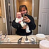 baby, bathroom, casual, child, door, happy, holding, indoor, light, mirror, mirror_selfie, pajamas, person, reflection, selfie, sink, smile, toiletries, woman, young
