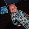 Janson joined the competition — help win amazing prizes! baby, infant, pajamas, cookie_monster, blue, blanket, pillow, smile, face, hand, lying_down, indoors, cute, child, person, apparel, pattern, bed, sleepwear, young