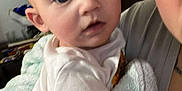 Zoe is registered to the contest to win money with this photo: baby, child, blanket, person, adult, indoor, closeup, holding, face, expression, clothing, soft, comfort, family, skin, head, arm, human, portrait, candid