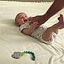 Zoe joined the competition — help win amazing prizes! baby, infant, blanket, hand, toy, teething_toy, carpet, footwear, slipper, person, playful, smiling, happy, indoor, floor, clothing, cute, child, adult_hand, interaction