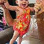 Zoe joined the competition — help win amazing prizes! baby, child, smiling, happy, person, holding_hands, colorful_clothing, orange, floral_pattern, indoor, sofa, adult, jeans, white_shirt, closeup, cute, playful, family, home, joy