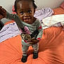 Maleah is registered to the contest to win money with this photo: toddler, child, bed, pajamas, indoor, person, holding_hand, smiling, hair_puffs, black_shoes, orange_bedspread, blanket, mickey_mouse, cute, young_child, standing, room, comfort, happy, casual_clothing