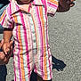 toddler, child, smiling, outdoor, holding_hands, striped_clothing, romper, pink_shoes, sunny, sidewalk, adult_hands, short_hair, earrings, playful, walking, street, grass, daytime, casual, happy