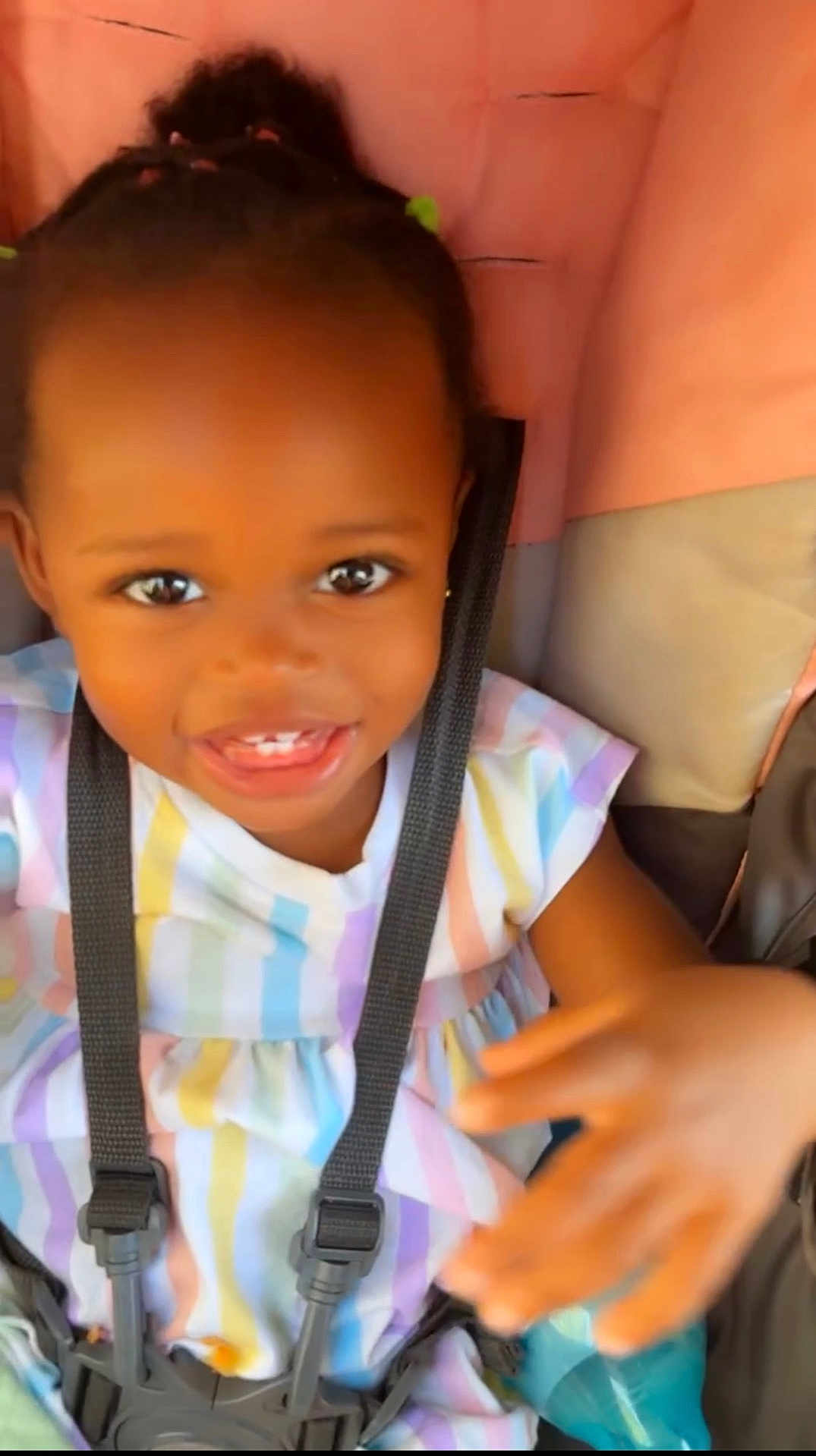 Maleah joined the competition — help win amazing prizes! child, toddler, smiling, face, dress, stripes, stroller, seatbelt, hand, happy, baby, infant, cute, person, portrait, colorful, young_child, seat, safety_harness, indoor