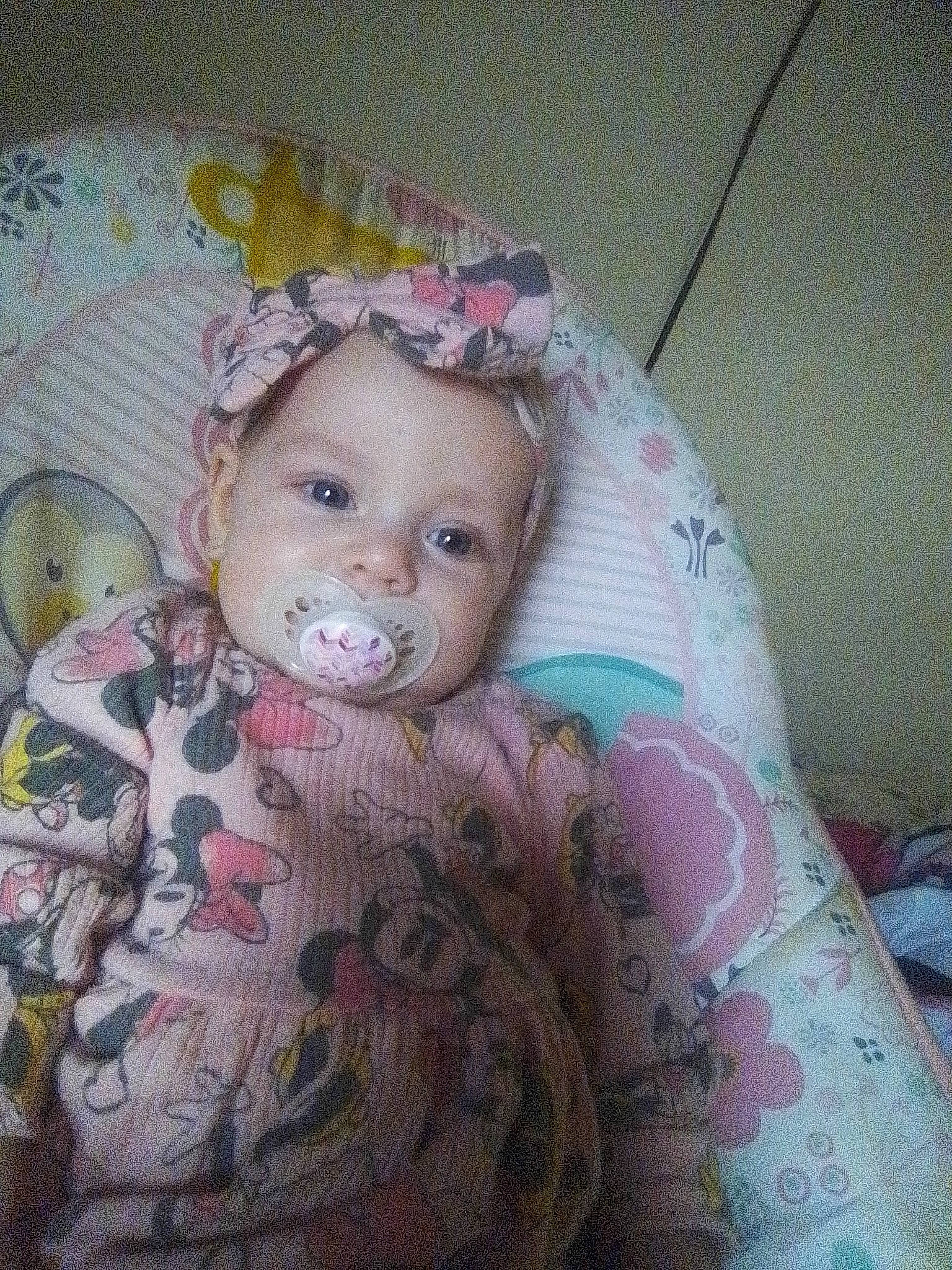 Harley is registered to the contest to win money with this photo: baby, baby_toddler_clothing, cheek, child, comfort, doll, dress, eye, eyelash, face, fashion_accessory, head, iris, linens, pattern, person, skin, sleeve, textile, toddler