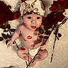 baby, bandana, lipstick_marks, roses, flower, diaper, fluffy_surface, cute, child, face, skin, hand, legs, expression, holding, red_color, sitting_pose, portrait, infant, playful