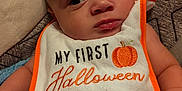 William is registered to the contest to win money with this photo: baby, bib, blanket, child, clothing, cozy, cute, expression, face, halloween, hand, indoors, infant, orange, person, portrait, pumpkin, soft, white, young