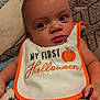 baby, bib, blanket, child, clothing, cozy, cute, expression, face, halloween, hand, indoors, infant, orange, person, portrait, pumpkin, soft, white, young