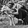 dog, woman, outdoor, nature, grass, black_and_white, hugging, pet, happy, crouching, boots, trees, animal, affection, friendship, canine, casual_clothing, leash, portrait, love