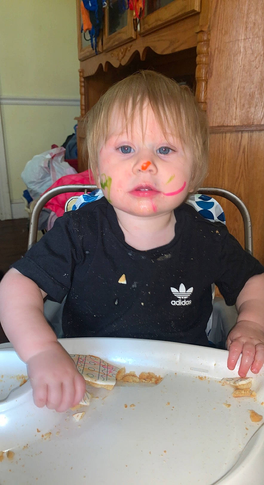 Adalynn is registered to the contest to win money with this photo: baby, baby_playing_with_food, blond, chair, cheek, child, chin, cuisine, dish, eye, face, food, food_craving, fun, hair, head, iris, person, t_shirt, tableware