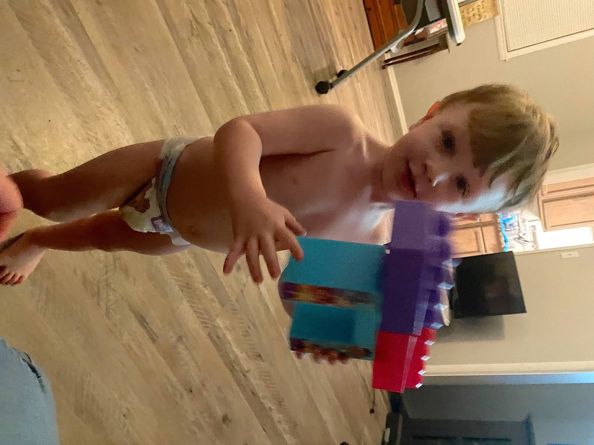 Austin is registered to the contest to win money with this photo: baby, barechested, chest, child, elbow, finger, flooring, fun, hardwood, human_leg, joint, person, picture_frame, play, smile, thigh, thumb, toddler, trunk, wood