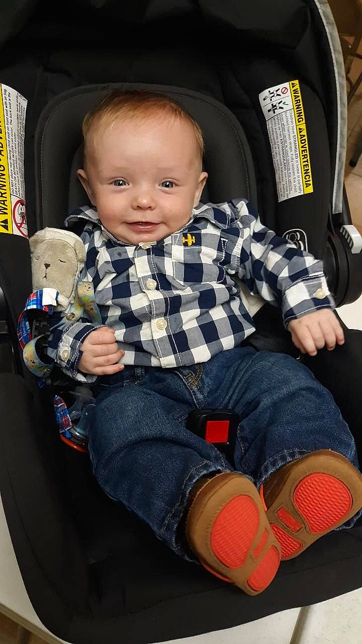 Castiel is registered to the contest to win money with this photo: baby_toddler_clothing, black, child, comfort, cool, face, fun, human_leg, knee, lap, person, plaid, shorts, sitting, sleeve, smile, sneakers, sock, tartan, thigh