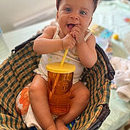 Isis participe au concours pour gagner de l'argent avec cette photo : baby, basket, blanket, child, clothing, cup, cute, feet, hands, indoor, pink_cap, plaid, playful, portrait, relaxed, sitting, smiling, straw, table, toy