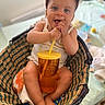 baby, basket, blanket, child, clothing, cup, cute, feet, hands, indoor, pink_cap, plaid, playful, portrait, relaxed, sitting, smiling, straw, table, toy