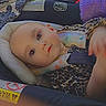 baby, child, car_seat, leopard_print, cushion, blanket, indoors, seat_belt, infant, portrait, clothing, person, cute, car, sitting, headrest, seat, soft_toy, young_child, looking