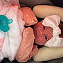 baby, infant, bow, pink_clothing, blanket, pacifier, car_seat, cushion, face, headwear, newborn, child, cute, indoors, soft_texture, resting, portrait, warm, comfort, sleepwear