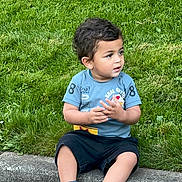 Avyaan joined the competition — help win amazing prizes! child, toddler, grass, sidewalk, curb, blue_shirt, black_shorts, sneakers, socks, outdoor, playing, sitting, young_child, casual_clothing, nature, greenery, daylight, cute, portrait, curious