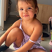 Djèlyssa participe au concours pour gagner de l'argent avec cette photo : cabinet, child, cute, dress, face, floor, furniture, hair, happy, indoor, legs, light, natural_light, person, sitting, skin, smile, socks, toddler, toy