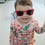toddler, child, sunglasses, pajamas, holiday, christmas, candy_cane, reindeer, floor, bedroom, bed, toy, smile, happy, indoor, person, clothing, light, wooden_floor, cute