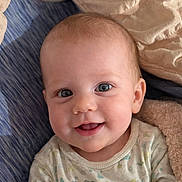 Raelynn is registered to the contest to win money with this photo: baby, infant, smiling, eyes, face, blanket, bedding, onesie, clothing, cozy, closeup, portrait, adorable, happy, chubby_cheeks, teeth, gaze, skin, head, ear