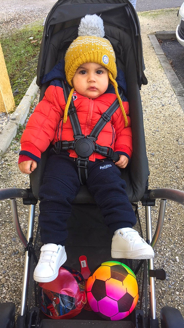 Jessim participe au concours pour gagner de l'argent avec cette photo : baby, baby_carriage, baby_products, baby_toddler_clothing, child, face, fun, green, headwear, leisure, person, personal_protective_equipment, photograph, product, shoe, snapshot, soccer, tire, toddler, wheel