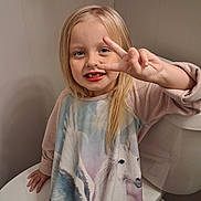 Presley joined the competition — help win amazing prizes! child, girl, smiling, portrait, blonde_hair, blue_eyes, front_facing, peace_sign, missing_teeth, long_hair, pink_clothing, dress, bathroom, bathtub, toilet, indoor, seated, happy, family_photo, close_up