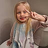 child, girl, smiling, portrait, blonde_hair, blue_eyes, front_facing, peace_sign, missing_teeth, long_hair, pink_clothing, dress, bathroom, bathtub, toilet, indoor, seated, happy, family_photo, close_up