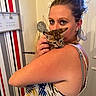 woman, kitten, cat, indoor, portrait, holding, shoulder, striped_wallpaper, home_decor, earrings, sunglasses, tank_top, tattoo, light, door, face, blue_eyes, animal, pet, cute