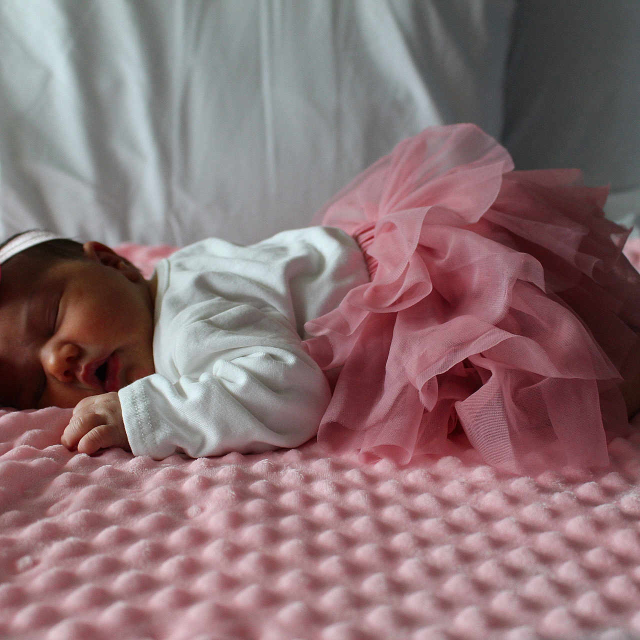 Cataleya participe au concours pour gagner de l'argent avec cette photo : baby, blanket, bow, child, cozy, cute, fabric, headband, indoors, infant, newborn, peaceful, pink, portrait, resting, skirt, sleeping, soft_texture, tutu, white_clothing