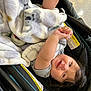 baby, blanket, stroller, child, smiling, happy, infant, face, clothing, arm, hair, indoor, cute, person, seat, comfort, infantwear, babycare, relaxation, playful
