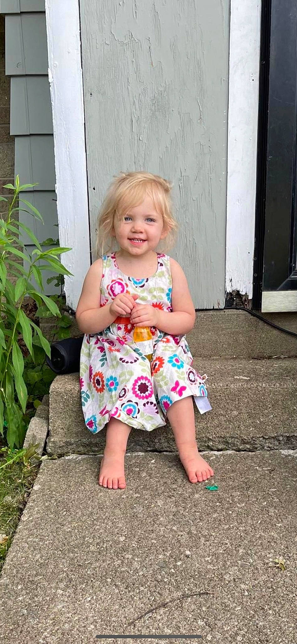 Lillyanna is registered to the contest to win money with this photo: baby_toddler_clothing, clothing, day_dress, dress, eye, grass, hair, hairstyle, human_body, joy, leaf, one_piece_garment, people_in_nature, person, pink, plant, skin, smile, standing, summer