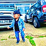 building, cap, car, casual, child, clothing, concrete, denim_jacket, driveway, fashion, footwear, ford, grass, outdoor, person, sidewalk, street, toddler, urban, window