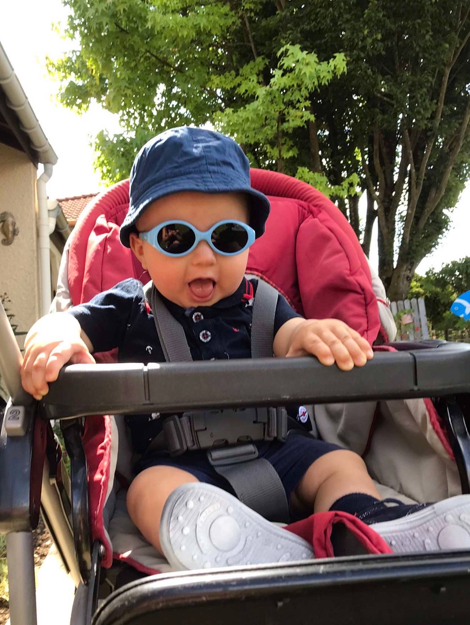 Yohan participe au concours pour gagner de l'argent avec cette photo : automotive_design, automotive_exterior, cap, carmine, eyewear, goggles, hat, headwear, lap, leisure, person, personal_protective_equipment, recreation, shorts, sitting, sunglasses, t_shirt, thigh, toddler, travel