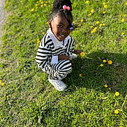 Kai joined the competition — help win amazing prizes! child, girl, smiling, outdoor, grass, flowers, yellow_flowers, sunlight, crouching, hair_beads, striped_clothing, casual_wear, white_shoes, nature, greenery, happy, portrait, daylight, young, person